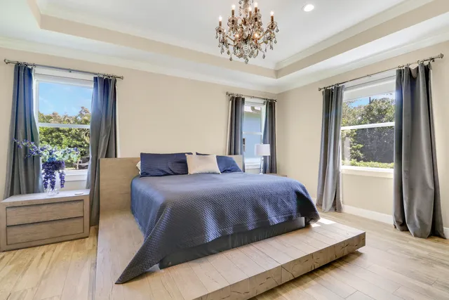 a bedroom with a large bed and a chandelier