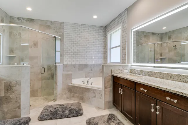 a bathroom with a double vanity sink a toilet and shower