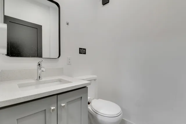 a bathroom with a toilet sink and mirror
