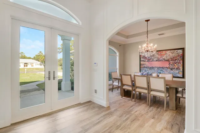 a view of a dining room with furniture a chandelier and wooden floor