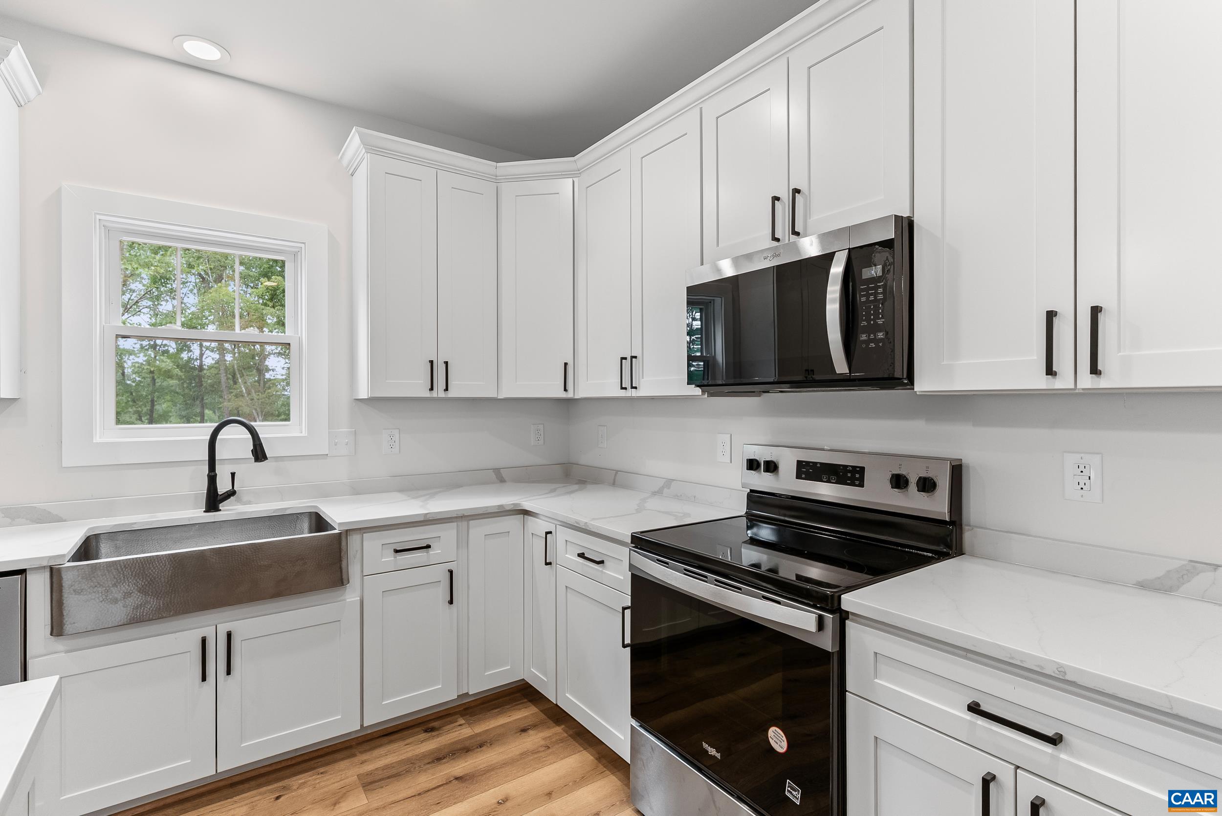 594 Community Road Dillwyn, VA 23936 - Photo 21 of 48 a kitchen with stainless steel appliances granite countertop a sink a stove a microwave and wooden cabinets