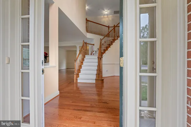 a view of staircase with wooden floor and white walls
