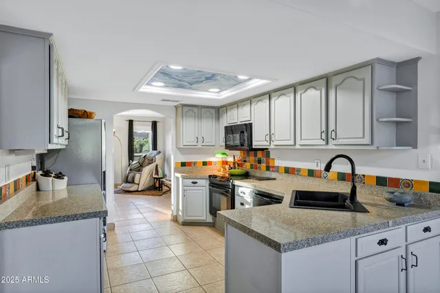 a kitchen with stainless steel appliances granite countertop a sink dishwasher and cabinets with wooden floor