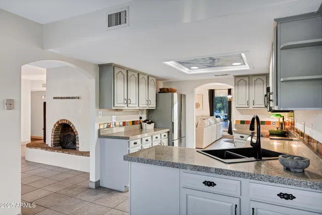 a kitchen with granite countertop a sink a stove and cabinets