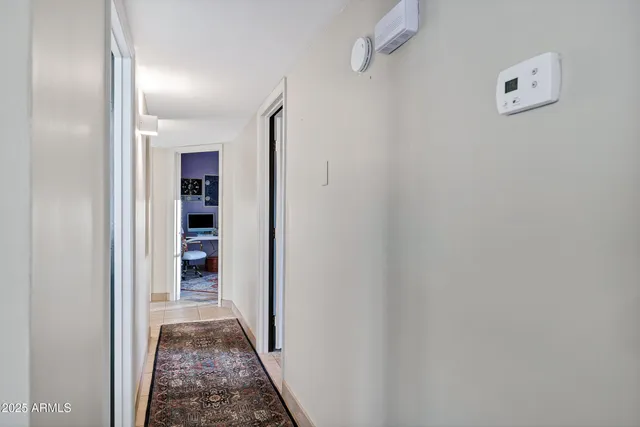 a view of a hallway with closet and a bathroom