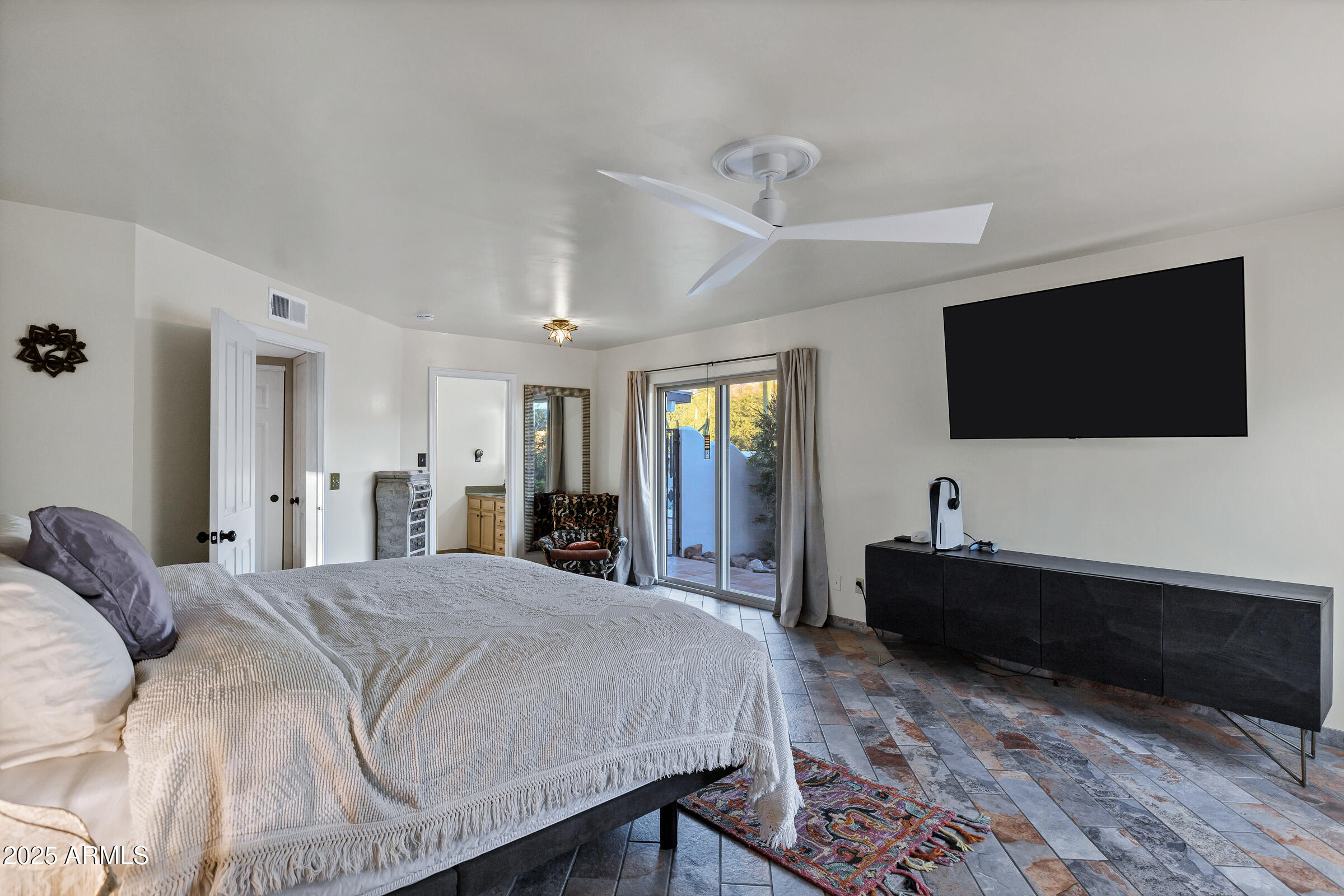 1291 South Red Rock Court Apache Junction, AZ 85119 - Photo 25 of 48 a spacious bedroom with a bed and a flat screen tv