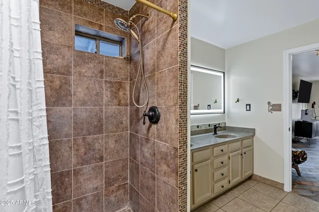 a spacious bathroom with a granite countertop sink a mirror and shower