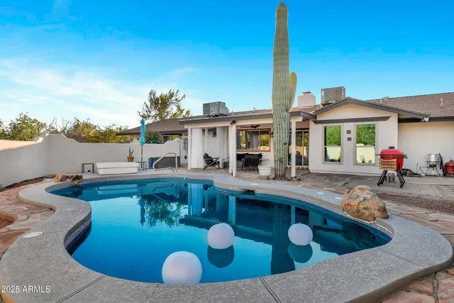 a view of a house with swimming pool and sitting area