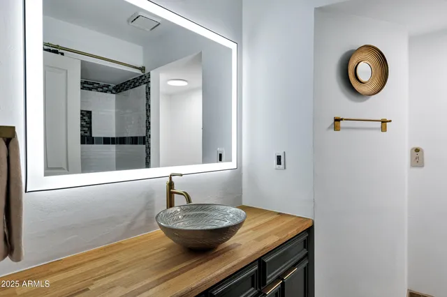 a bathroom with a granite countertop sink and a mirror