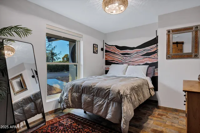 a bedroom with a bed and painting on the wall