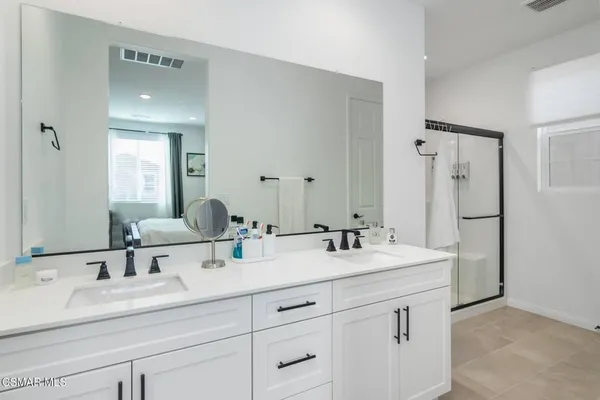 a bathroom with double sink and a mirror