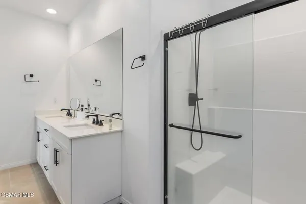 a bathroom with a shower sink and mirror
