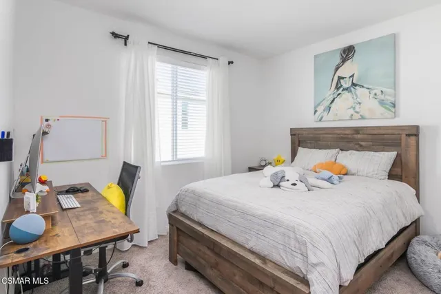 a bedroom with a bed a dresser and a window