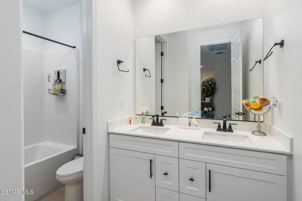 a bathroom with a double vanity sink toilet and shower