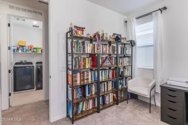 a living room with a book shelf and a shelf