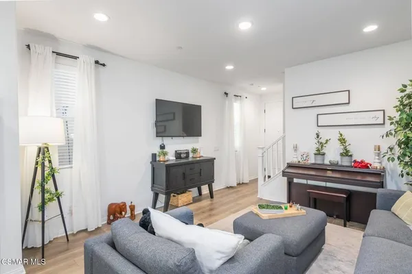 a living room with furniture a flat screen tv and a chandelier