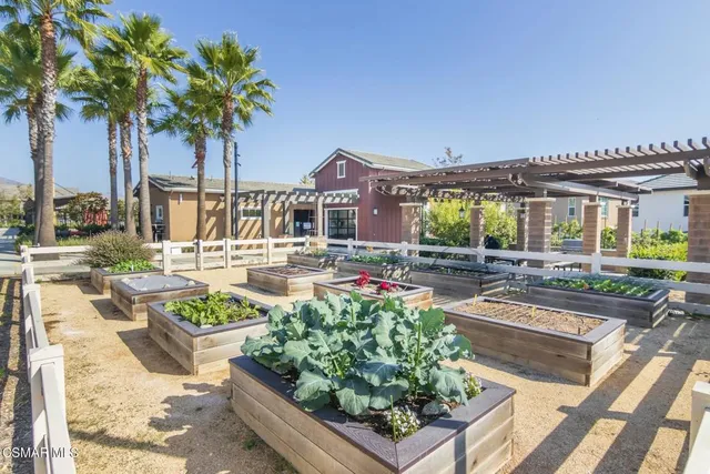 a front view of a house with garden and sitting area