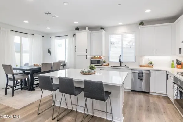 a kitchen with a sink cabinets and chairs
