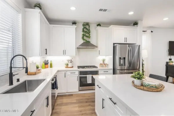 a kitchen with stainless steel appliances granite countertop a stove a sink and a refrigerator