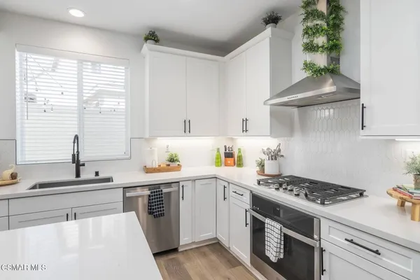 a kitchen with a stove a sink and a window