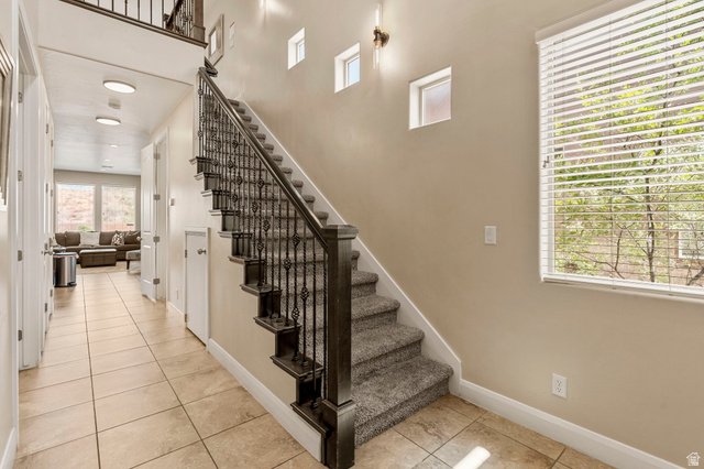 4257 Razor Drive Washington, UT 84780 - Photo 13 of 58 Inviting entryway featuring tile flooring, a carpeted staircase with ornate iron balusters and a dark wood handrail, multiple windows, and recessed lighting