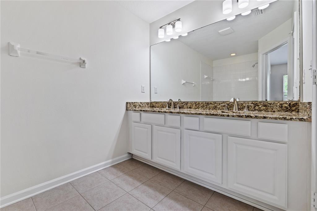 8520 Sandy Beach Street Tampa, FL 33634 - Photo 19 of 25 a bathroom with a granite countertop sink and a mirror