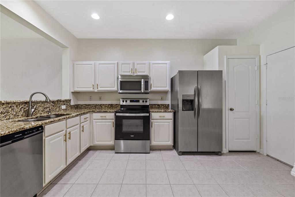 8520 Sandy Beach Street Tampa, FL 33634 - Photo 6 of 25 a kitchen with stainless steel appliances granite countertop a refrigerator and a stove top oven