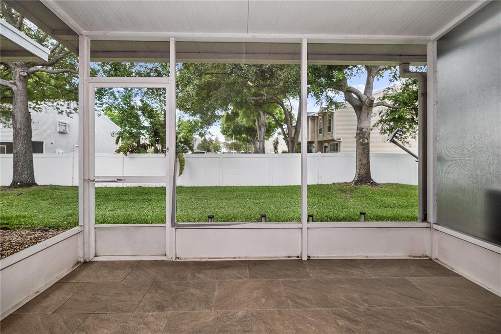 8520 Sandy Beach Street Tampa, FL 33634 - Photo 9 of 25 a view of a porch with a big yard and potted plants