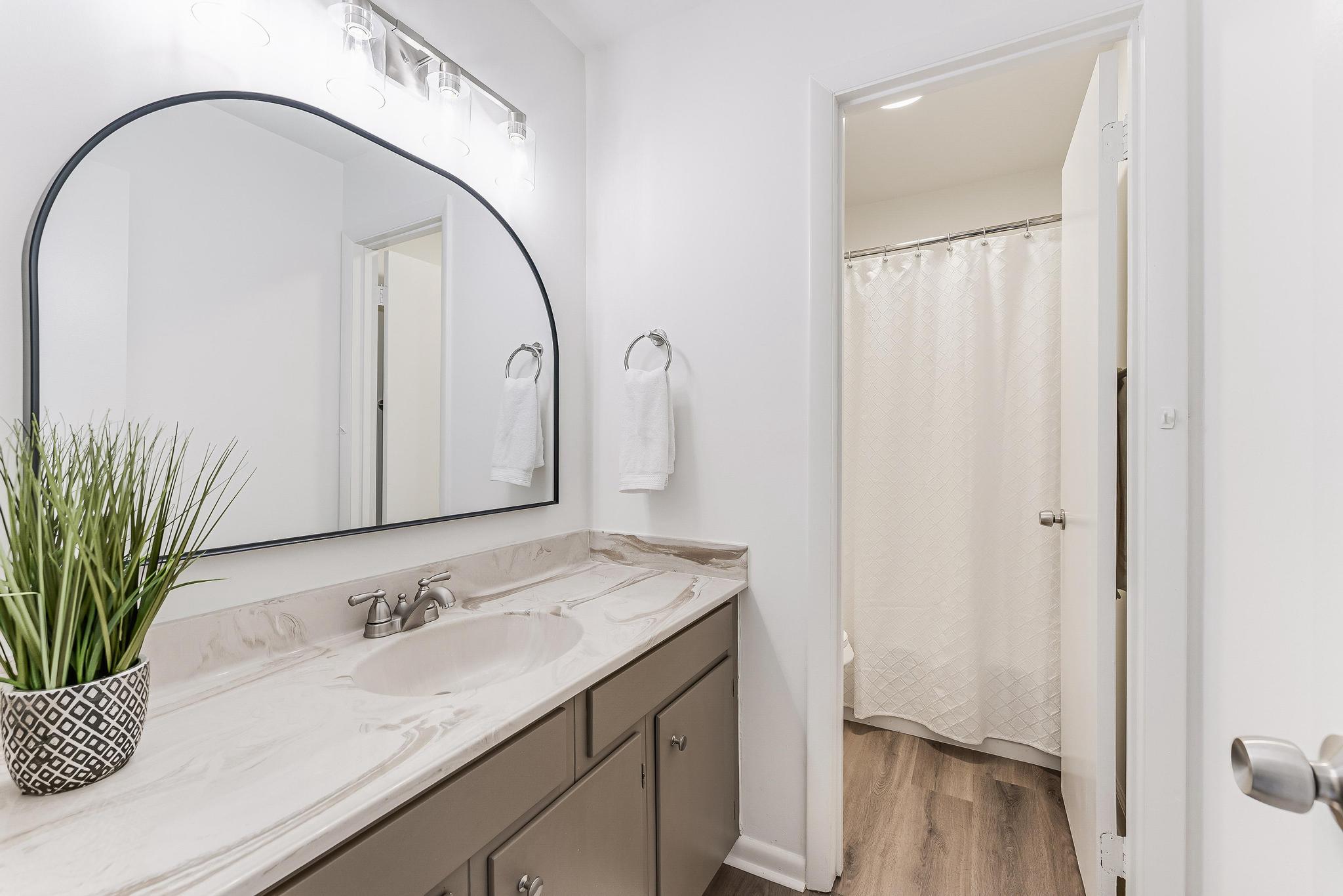12023 Insha Court Reston, VA 20191 - Photo 44 of 52 a bathroom with a granite countertop sink a mirror and shower