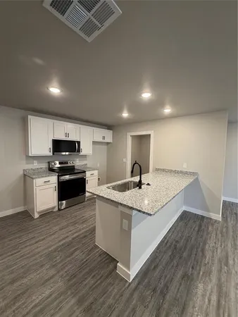 a kitchen with stainless steel appliances granite countertop a sink and stove top oven