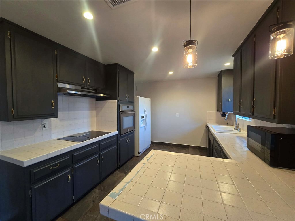 607 Sixth Street Norco, CA 92860 - Photo 11 of 17 a kitchen with granite countertop a sink a counter top space stainless steel appliances and cabinets