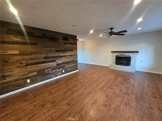 a view of an empty room with a fireplace and a fan