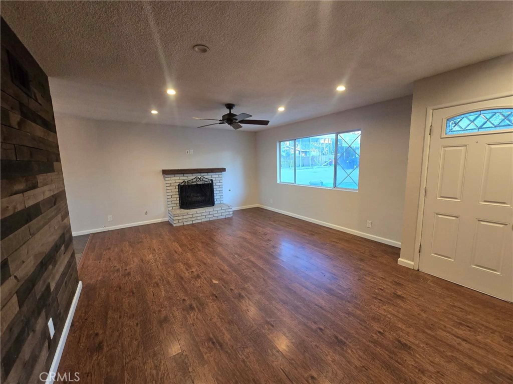 607 Sixth Street Norco, CA 92860 - Photo 5 of 17 an empty room with windows fireplace and wooden floor