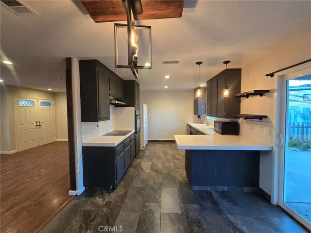 a large kitchen with a sink and dishwasher a refrigerator with wooden floor