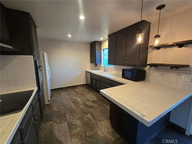 a kitchen with stainless steel appliances cabinets and wooden floor