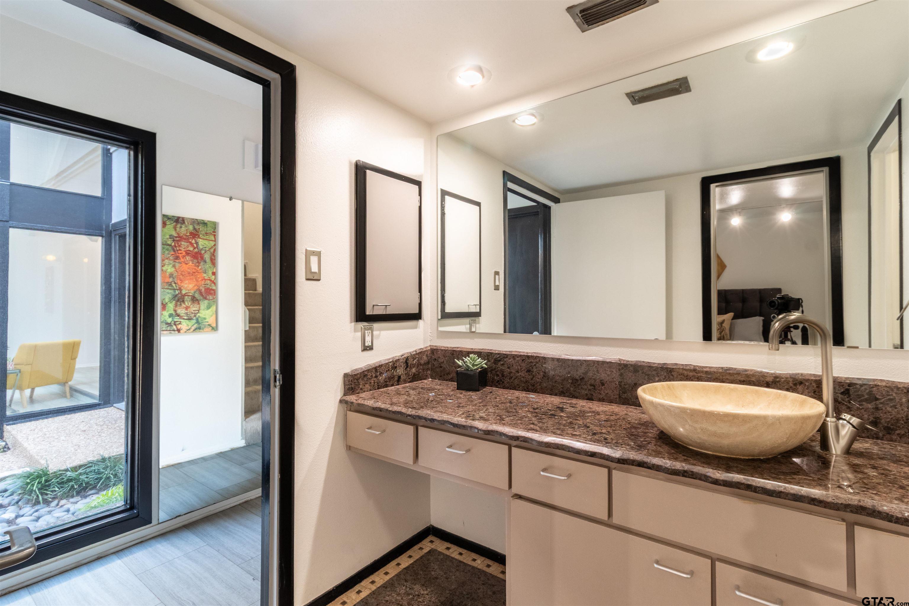 520 East Lake Street Tyler, TX 75701 - Photo 20 of 41 a spacious bathroom with a granite countertop sink and a mirror