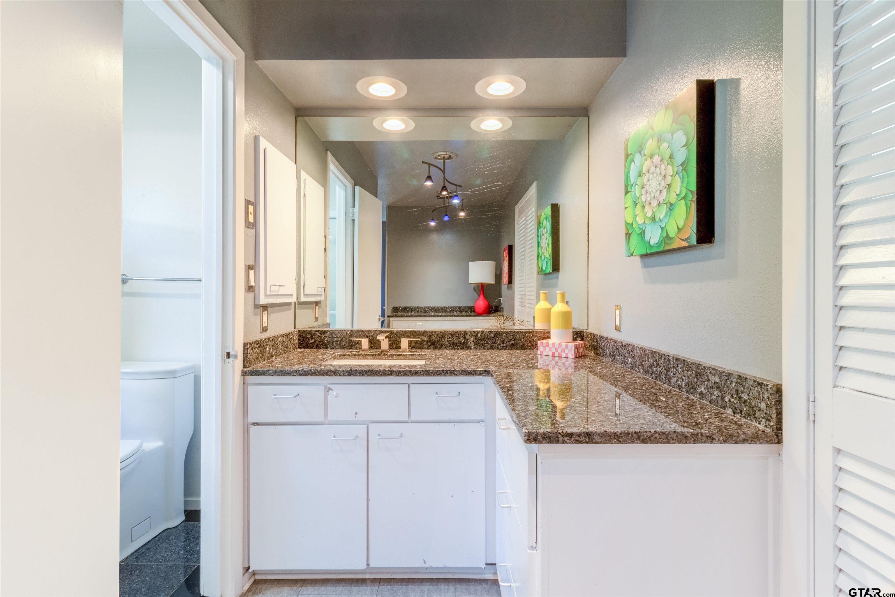 520 East Lake Street Tyler, TX 75701 - Photo 25 of 41 a bathroom with a granite countertop sink and a mirror