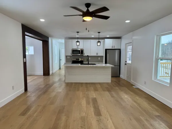 a view of kitchen with refrigerator microwave and wooden floor