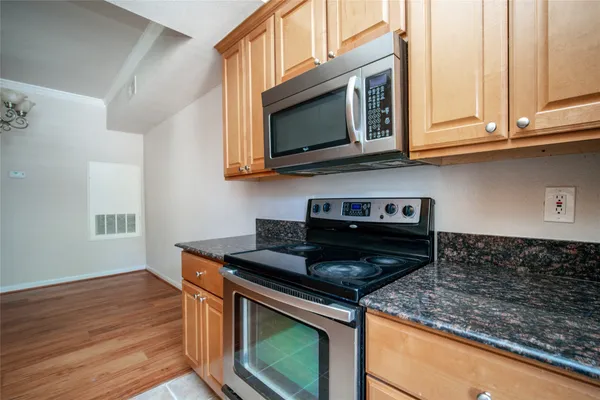 a kitchen with stainless steel appliances granite countertop a stove microwave and sink