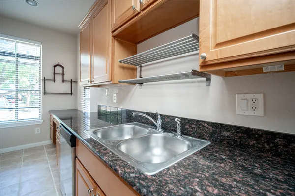 a kitchen sink with granite countertop a sink and a stove