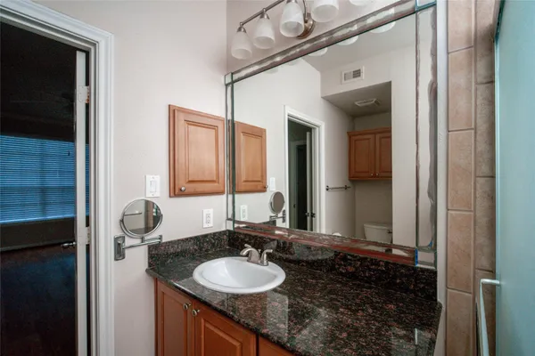 a bathroom with a granite countertop sink and a mirror
