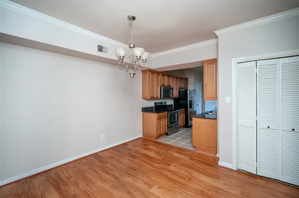 a view of a room with wooden floor and kitchen view