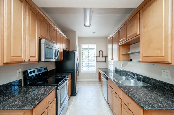 a kitchen with stainless steel appliances granite countertop a stove a sink and a microwave