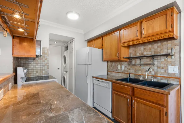 a kitchen with stainless steel appliances granite countertop a refrigerator a sink and dishwasher