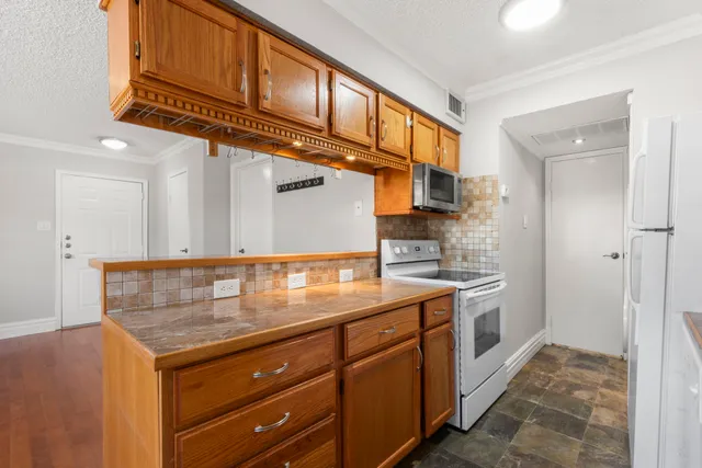 a kitchen with stainless steel appliances granite countertop a refrigerator and a sink
