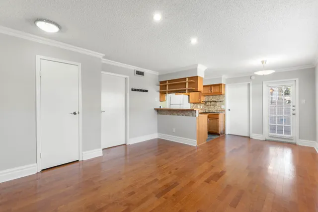 a view of a kitchen with wooden floor electronic appliances and window