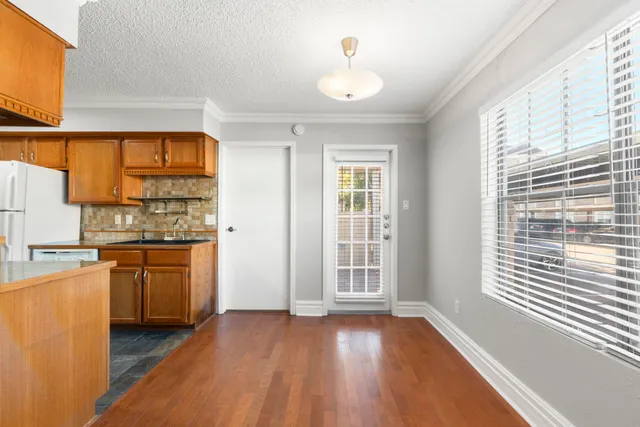 a view of a kitchen with wooden floor and stainless steel appliances