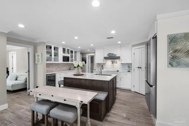 a bedroom with a bed a dresser and a chandelier