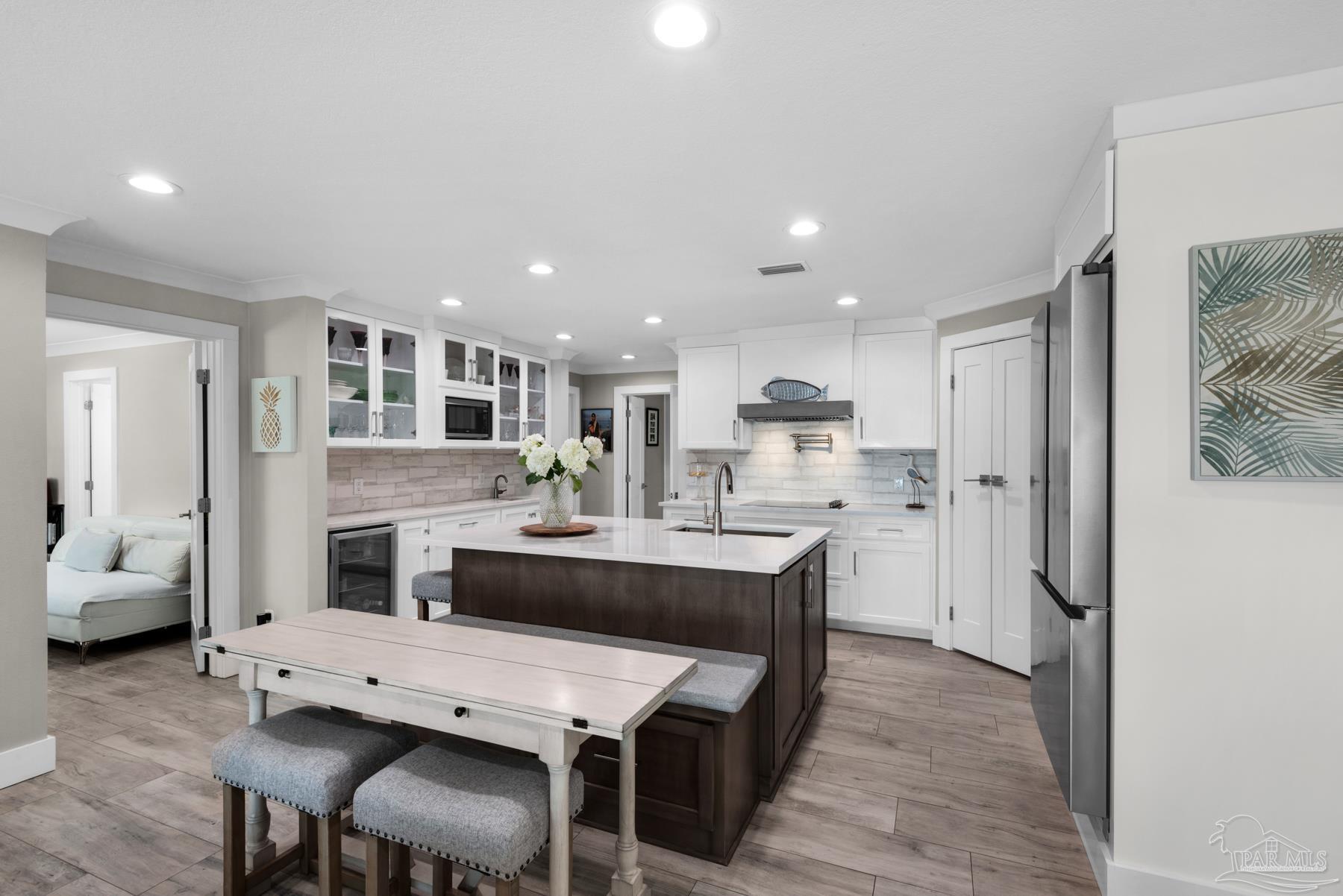 2829 Bay Street Gulf Breeze, FL 32563 - Photo 13 of 69 a dining hall with stainless steel appliances kitchen island granite countertop a dining table chairs and a refrigerator