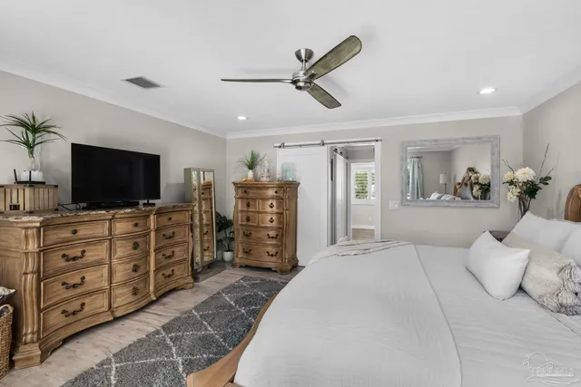 a bedroom with a bed a dresser and a flat screen tv